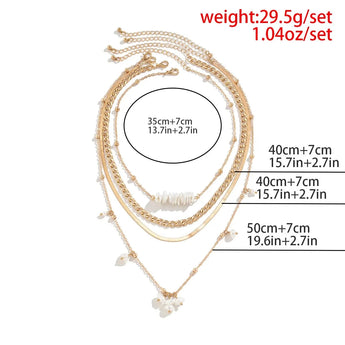 Gold layered necklaces set with pearl pendant, featuring a chunky chain and stylish chokers, worn around a woman's neck.