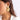 A woman wearing large textured botanical gold leaf statement earrings.