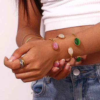 A woman's wrist adorned with a luxurious gold pink cabochon bracelet, highlighting the elegance of designer jewelry.