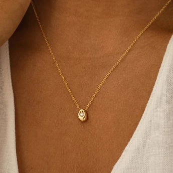 A minimalist gold stainless steel pendant necklace worn on a woman's neck, showcasing its hypoallergenic and tarnish-resistant properties.