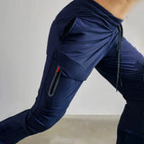 Gray men's tapered joggers being worn, highlighting the lightweight athletic sweatpants design with a comfortable fit around the waist, thighs, and knees, suitable for sports and active wear.