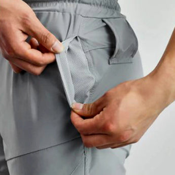 Gray men's tapered joggers worn by a model, highlighting the lightweight fabric and athletic design. The joggers are paired with a casual top, showcasing the comfort and style suitable for both exercise and leisure.