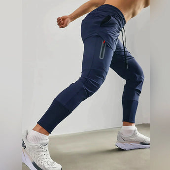 Men's gray tapered joggers displayed, showcasing a lightweight athletic design with a focus on comfort and style. The sweatpants feature a fitted waist and tapered legs, ideal for sportswear or casual fashion.