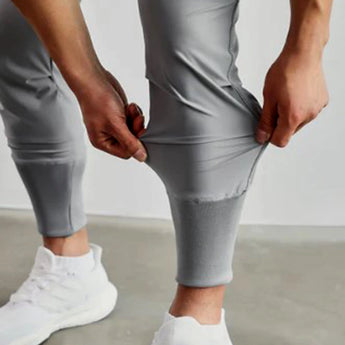 Men wearing gray tapered joggers paired with casual white shoes, showcasing a relaxed athletic style.