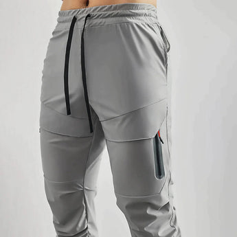 Gray men's tapered joggers made of lightweight fabric designed for athletic activities, featuring a comfortable fit around the waist and legs.