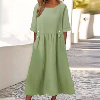Light green loose-fit midi dress with elbow sleeves, designed for summer in a comfortable cotton streetwear style. The dress features a relaxed fit with a focus on the shoulder and waist area, providing casual elegance. Suitable for day wear or casual events. Modeled in size 3XL.