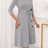 Gray plus size midi dress with tie-waist and button-front design, featuring long sleeves and tailored for a casual work setting.