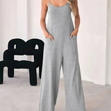 Woman wearing a gray sleeveless casual wide leg jumpsuit, standing, summer loungewear, size XL.