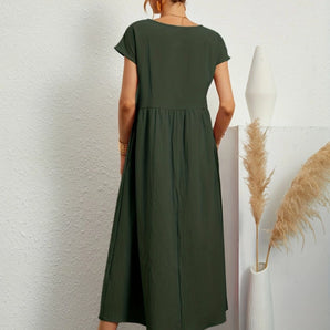 A-line midi dress in a soft green color, featuring short sleeves, a fitted waist, and a rounded neckline. The dress falls to knee length, ideal for casual summer wear.