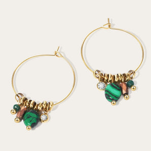 Gold-tone hoop earrings adorned with green crystals from YA-CHAN Luxury Designer Jewelry.