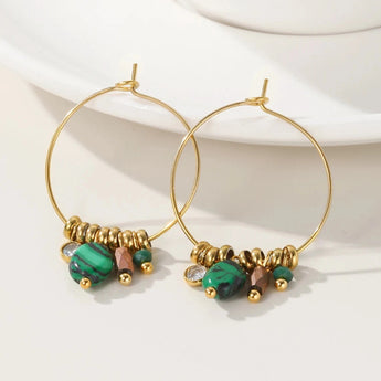 Gold hoop earrings with green crystal pendants from YA-CHAN Luxury Designer Jewelry displayed on a white background.