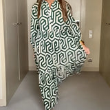 
Woman wearing a green geometric long sleeve midi dress with a fitted waist, collar, and knee-length hem, perfect for fall fashion. She is smiling, adding a cheerful vibe to the outfit.