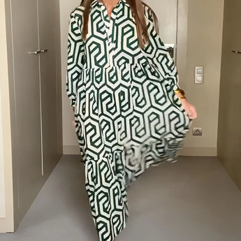 
Woman wearing a green geometric long sleeve midi dress with a fitted waist, collar, and knee-length hem, perfect for fall fashion. She is smiling, adding a cheerful vibe to the outfit.