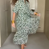 
A woman wearing a green geometric long sleeve midi dress, showcasing a stylish fall fashion piece with a fitted waist and elegant neckline.