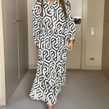 
A woman wearing a black long sleeve midi dress with a geometric design, featuring a fitted waist and a high collar, showcasing fall fashion for women.