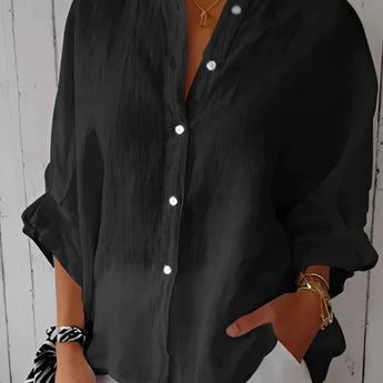 A black women's relaxed fit button-down blouse made of linen, featuring long sleeves and a classic collar.