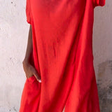 A woman wearing a green linen tunic dress, featuring an oversized and casual fit, perfect for summer; the dress is breathable and stylish with a focus on comfort and fashion.