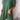 A woman wearing a green linen tunic dress, featuring an oversized and casual summer design with breathable fabric and stylish details.