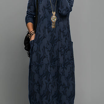 Blue long sleeve midi dress featuring a tribal necklace, highlighted by its patterned design, suitable for daytime wear.
