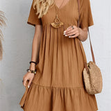 A woman wearing a brown short sleeve midi dress with pleats, suitable for summer casual wear, in size 3XL.