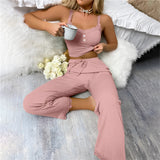 Woman wearing a pink ribbed lace trim jumpsuit, showcasing comfortable loungewear with emphasis on shoulder, arm, waist, and thigh areas.