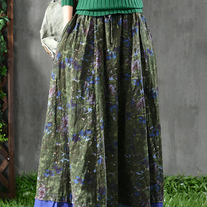 Women's fall fashion outfit featuring a green ribbed sweater with sleeves and a floral maxi skirt in hues of blue and purple, displayed in a photograph.