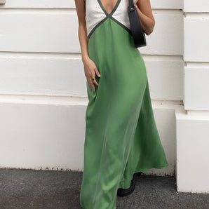 Green satin maxi dress with contrast straps, designed for elegant evening wear, highlighted by its flowing silhouette and sophisticated style. The dress features a fitted waist, a flattering neckline, and is tailored to a 3XL size, showcasing the shoulder and knee-length design.