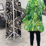 Green tropical print women's designer statement jacket featuring chic lightweight material, showcasing vibrant patterns and a stylish design with a focus on fashion detailing like structured shoulders, defined neckline, and tailored sleeves.