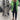 Green tropical print women's designer statement jacket in lightweight fabric, shown in XXXL size. The chic outerwear features a vibrant pattern, with long sleeves and a flattering cut around the shoulders and waist. The model is standing, showcasing the jacket's fashionable design.