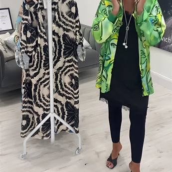 Green tropical print women's designer statement jacket in lightweight fabric, shown in XXXL size. The chic outerwear features a vibrant pattern, with long sleeves and a flattering cut around the shoulders and waist. The model is standing, showcasing the jacket's fashionable design.