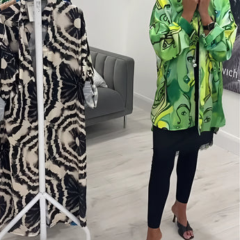Women's designer statement jacket featuring a green tropical print, showcasing lightweight and chic style with detailed sleeves and a fashionable neckline.