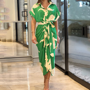 Green and white abstract print V-neck wrap midi dress in a summer fashion style, featuring short sleeves and a fitted waist, worn by a fashion model.