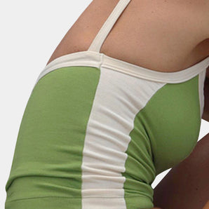 Women's green and white racerback yoga tank top designed for moisture-wicking, displayed on a model showcasing sportswear options for the gym with focus on shoulder, waist, and thigh areas.