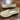 Beige lightweight breathable slip-on sneakers on a wooden surface, showcasing their water-resistant design and stylish appearance.