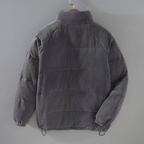 Grey corduroy high neck winter jacket with adjustable features, displayed on a clothes hanger, highlighting its warm and urban style with a focus on the collar and sleeve design.