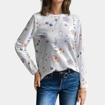 Grey floral linen blouse featuring a delicate botanical pattern, showcasing long sleeves, a modest neckline, and a natural fabric texture.