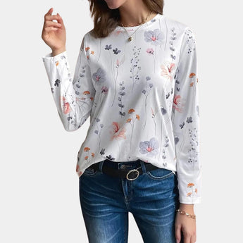 Grey floral linen blouse with delicate botanical patterns, featuring a white color scheme, long sleeves, and a classic dress shirt design. The blouse is crafted from natural fabric, highlighting the texture and quality of the textile.
