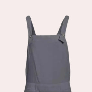 Grey women's utility overalls with adjustable straps and multiple pockets, designed for practicality and style. The overalls are displayed against a plain backdrop highlighting their utility features.