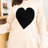 Heart pattern grey oversized sweater in apricot color, worn by a woman with a cozy fit, featuring long sleeves and a relaxed neckline.