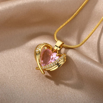 Heart-shaped pink gemstone gold necklace adorned with diamond-encrusted heart pendant.