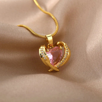 Heart-shaped pink gemstone gold necklace with diamond-encrusted heart pendant.