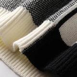 Black and white herringbone knit sweater featuring a distinctive winter pattern, with long sleeves and a cozy texture ideal for cold weather fashion.