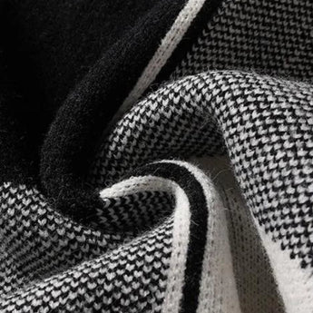 Black and white herringbone knit sweater with long sleeves, showcasing a close-up view of the intricate pattern and texture.