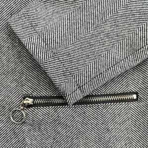 Grey herringbone slim fit blazer for women with a stylish hidden zipper, featuring a long sleeve design and tailored fit in a monochrome pattern.
