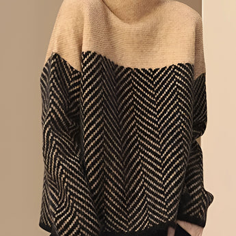 
A woman wearing a khaki, oversized wool blend sweater with a high-neck chevron pattern, showcasing long sleeves and a comfortable fit suitable for winter fashion.