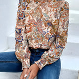 
A stylish high-neck paisley blouse featuring a bohemian design, perfect for autumn. The blouse showcases a detailed paisley pattern with long sleeves and a relaxed fit, emphasizing fashion-forward shoulder and neck detailing.