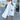 White maxi dress with high slit and strappy back design, featuring a sleeveless style and fitted waist, resembling a bridal party dress.
