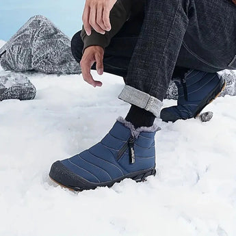 A person wearing high-traction anti-slip rubber sole athletic sneakers standing in a snowy outdoor environment, with visible legs covered by sportswear.