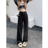 Woman wearing high-waist beige palazzo trousers, showcasing casual streetwear style with a focus on the waist and leg area.