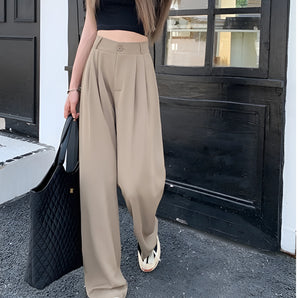 High-waist beige palazzo trousers for women, shown in a casual streetwear outfit. The model is standing, highlighting the fit around the waist and the wide-leg design.